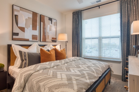 Comfortable bedroom with large window decorated in warm earth tones.